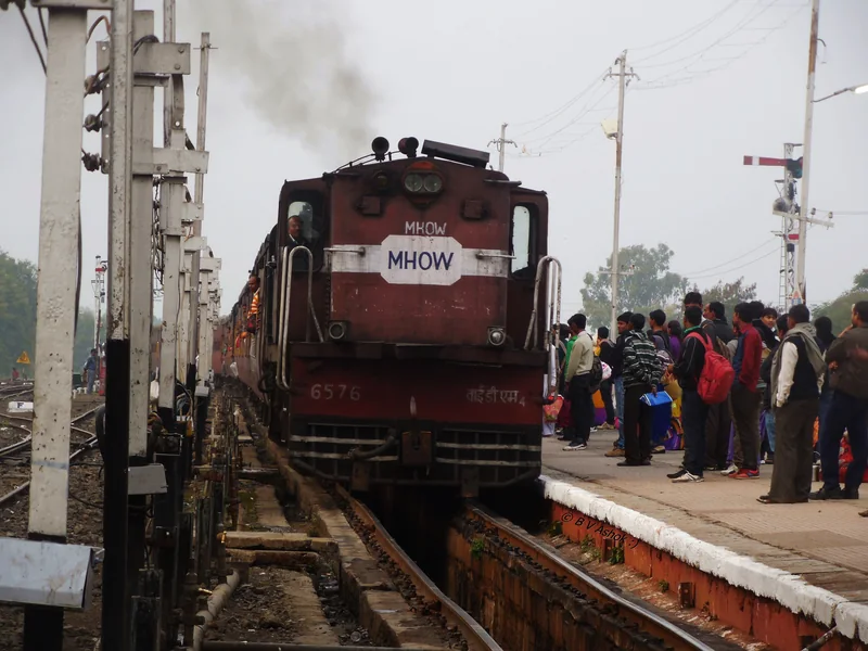 महू स्टेशन पर लाल रंग का YDM-4 डीजल इंजन और प्लेटफॉर्म पर खड़े यात्री